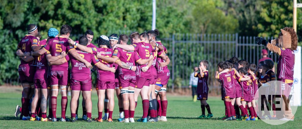 Wests Scarborough Premier Grade in a huddle with junior players watching on at Bennett Park